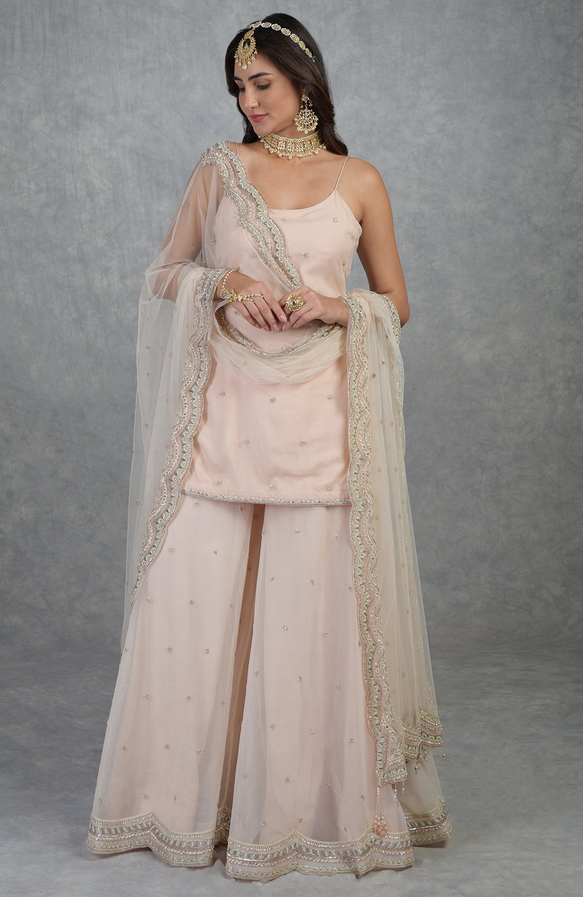 Champagne pink sharara set with hand-embroidered beads, sequins, crystals, and floral motifs.