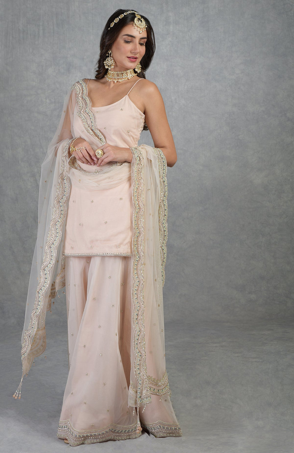 Champagne pink sharara set with hand-embroidered beads, sequins, crystals, and floral motifs.