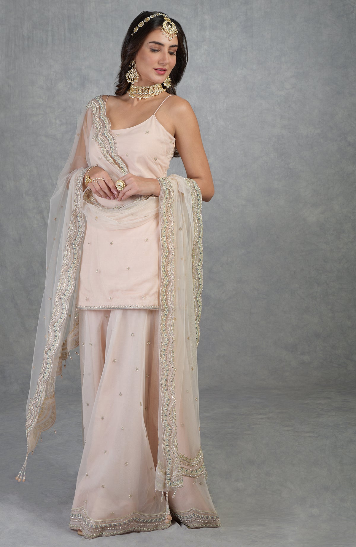 Champagne pink sharara set with hand-embroidered beads, sequins, crystals, and floral motifs.