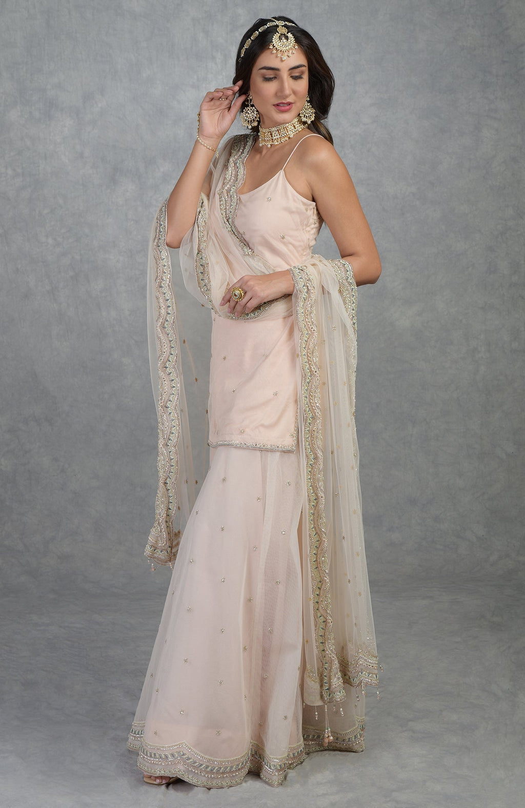 Champagne pink sharara set with hand-embroidered beads, sequins, crystals, and floral motifs.