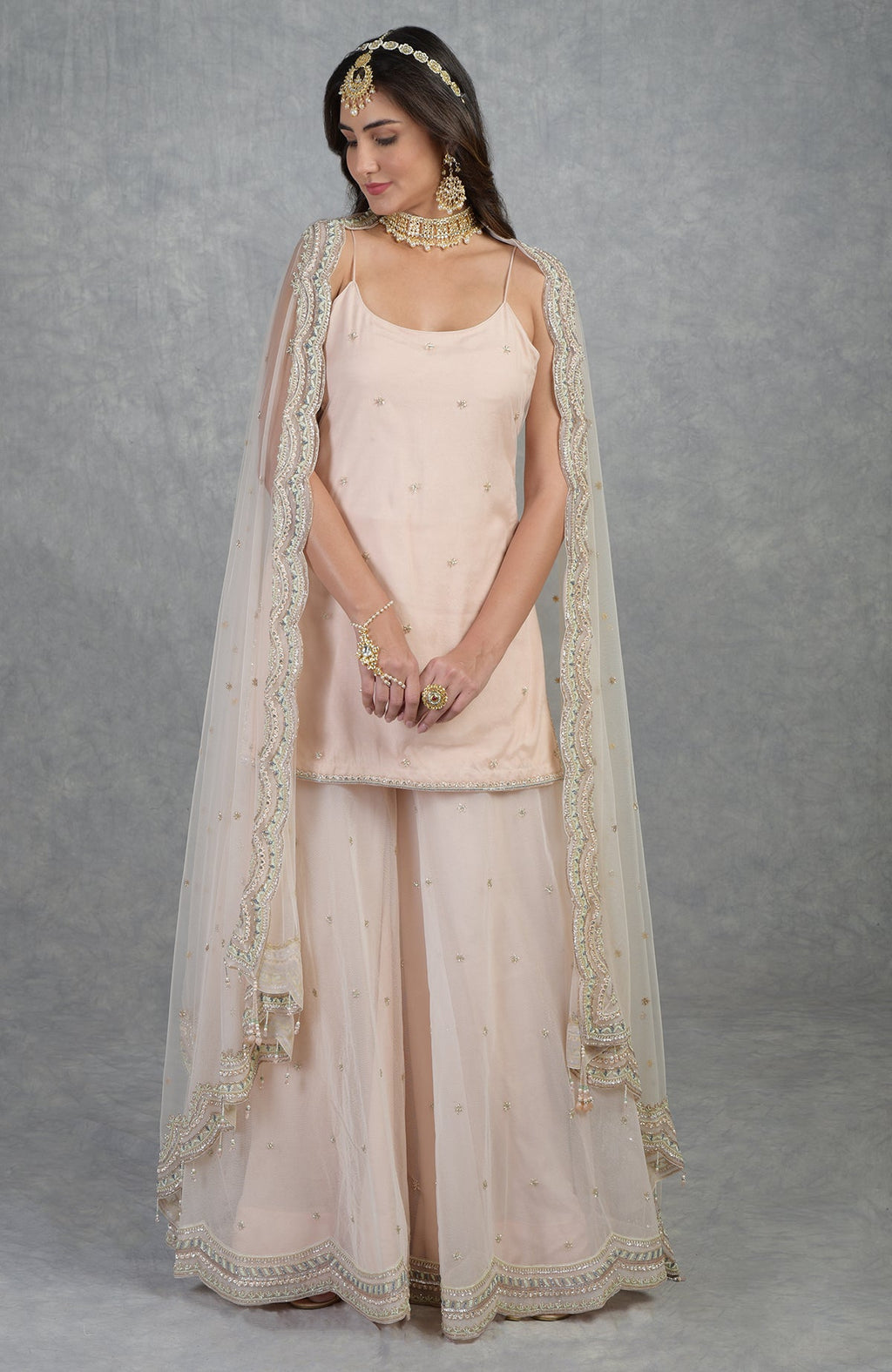 Champagne pink sharara set with hand-embroidered beads, sequins, crystals, and floral motifs.