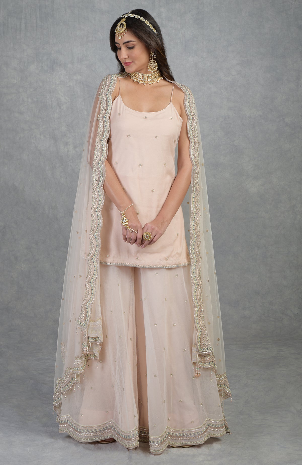 Champagne pink sharara set with hand-embroidered beads, sequins, crystals, and floral motifs.