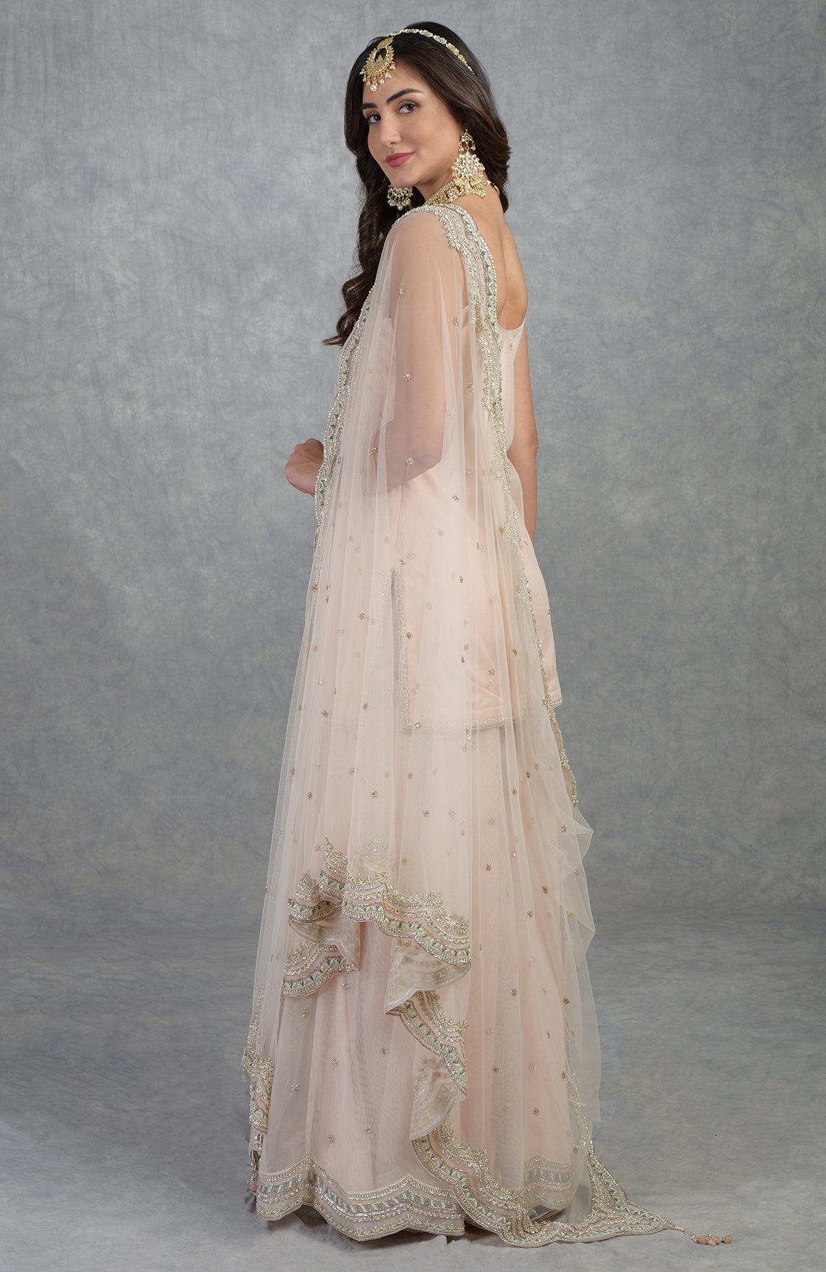 Champagne pink sharara set with hand-embroidered beads, sequins, crystals, and floral motifs.