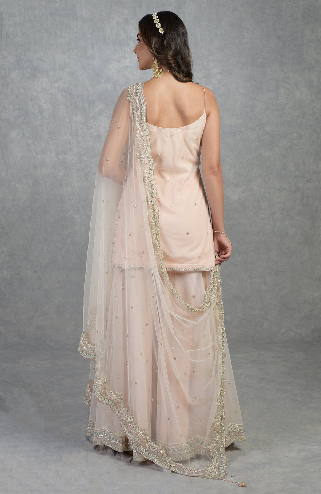 Champagne pink sharara set with hand-embroidered sequins, beads, crystals, and floral motifs.