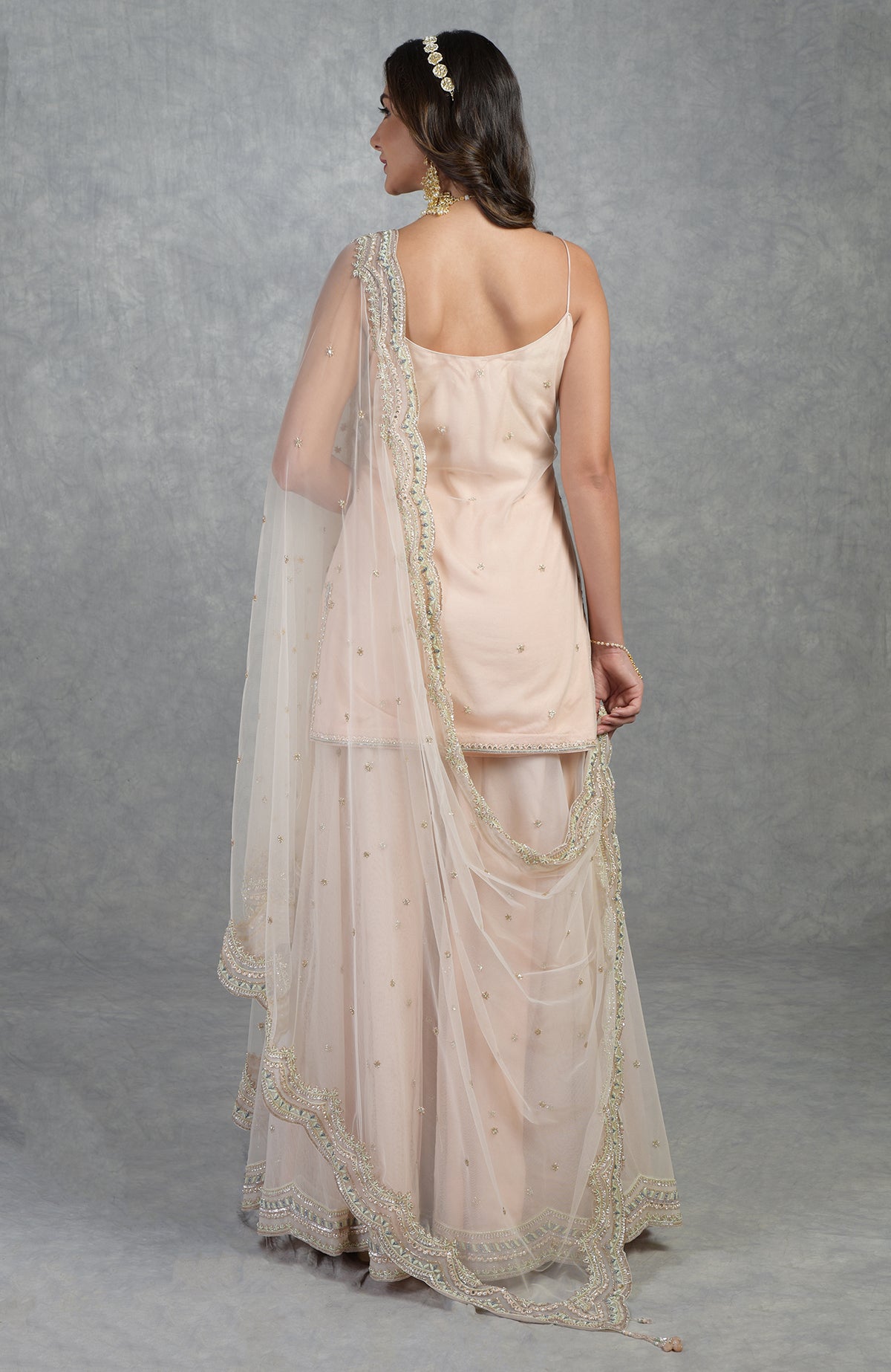 Champagne pink sharara set with hand-embroidered sequins, beads, crystals, and floral motifs.