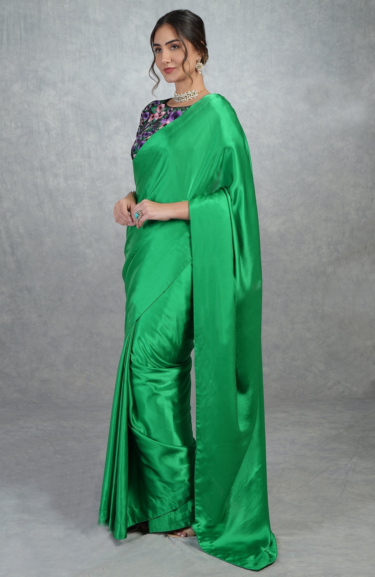 Emerald green satin silk saree with black floral embroidered blouse with cap sleeves and boat neck