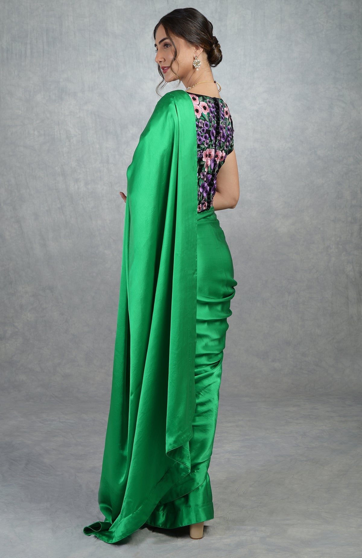 Emerald green satin silk saree with black floral embroidered blouse with cap sleeves and boat neck
