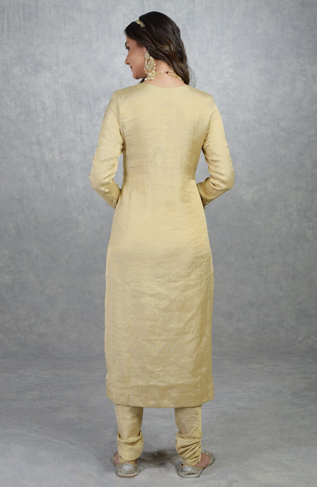 Gold tissue suit with straight cut kurta, round neck, long sleeves, and churidar pants.
