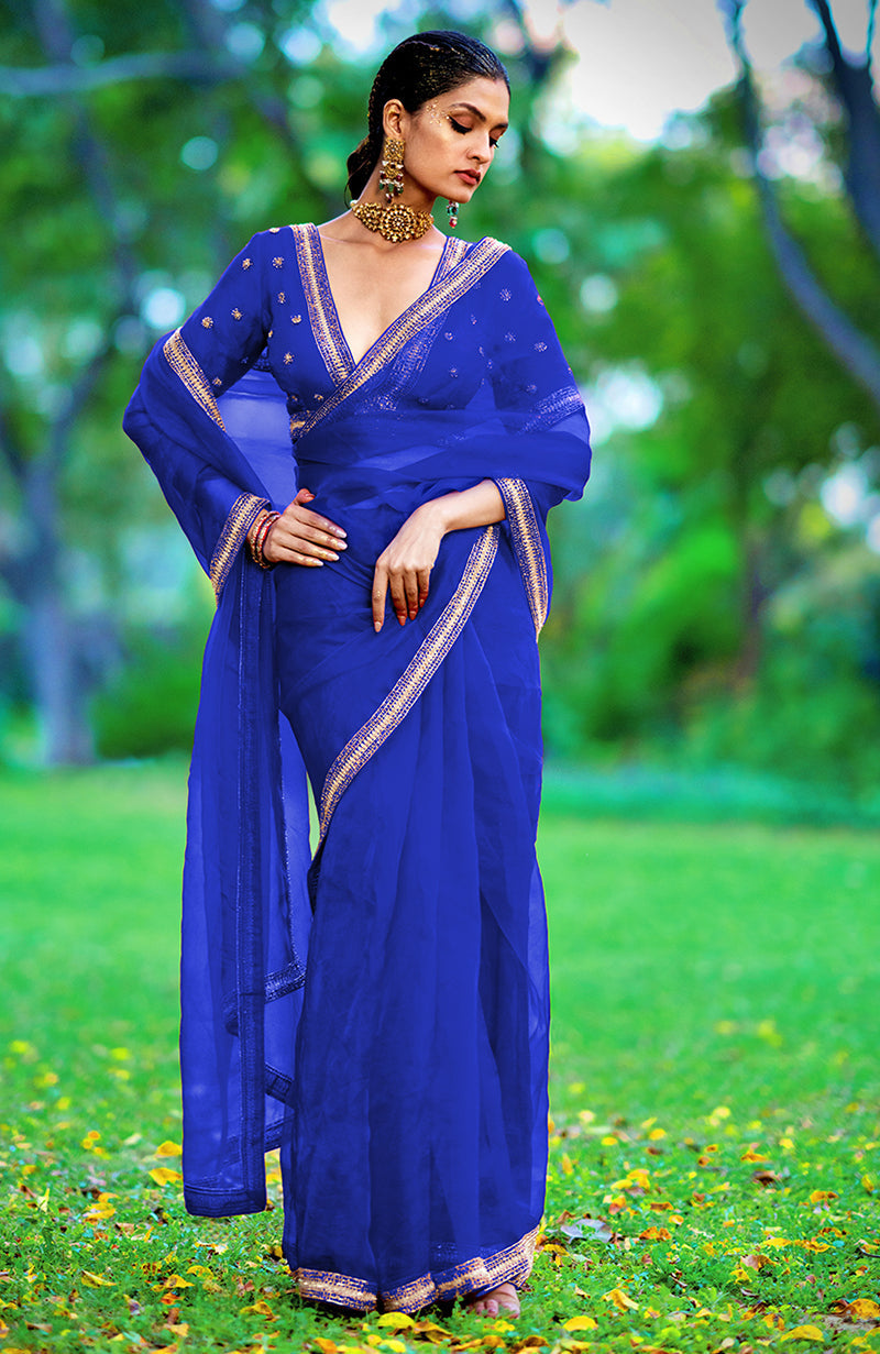 A woman in a royal blue crystal beads and zari hand-embroidered saree.