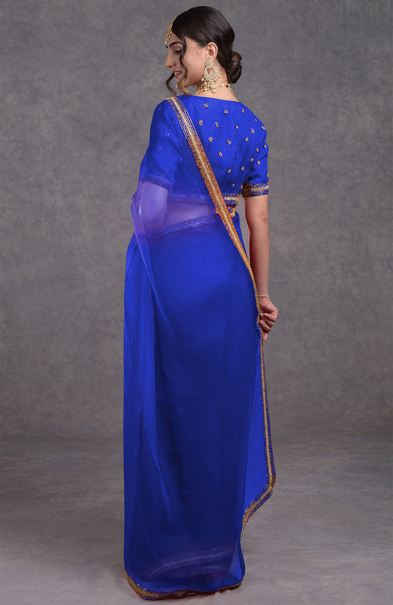 A woman models a royal blue crystal beads and zari hand-embroidered saree.