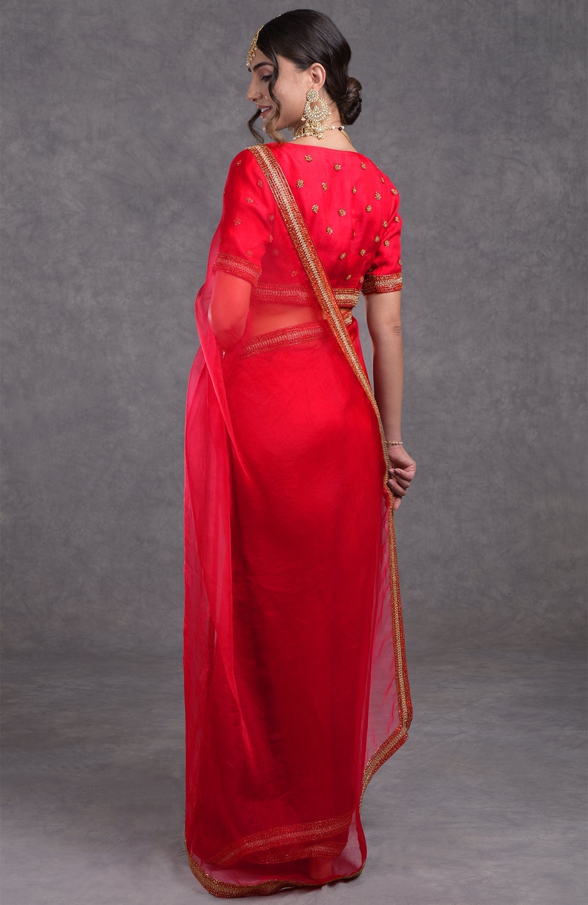 Red organza silk saree with gold and red crystal bead and zari hand embroidery.