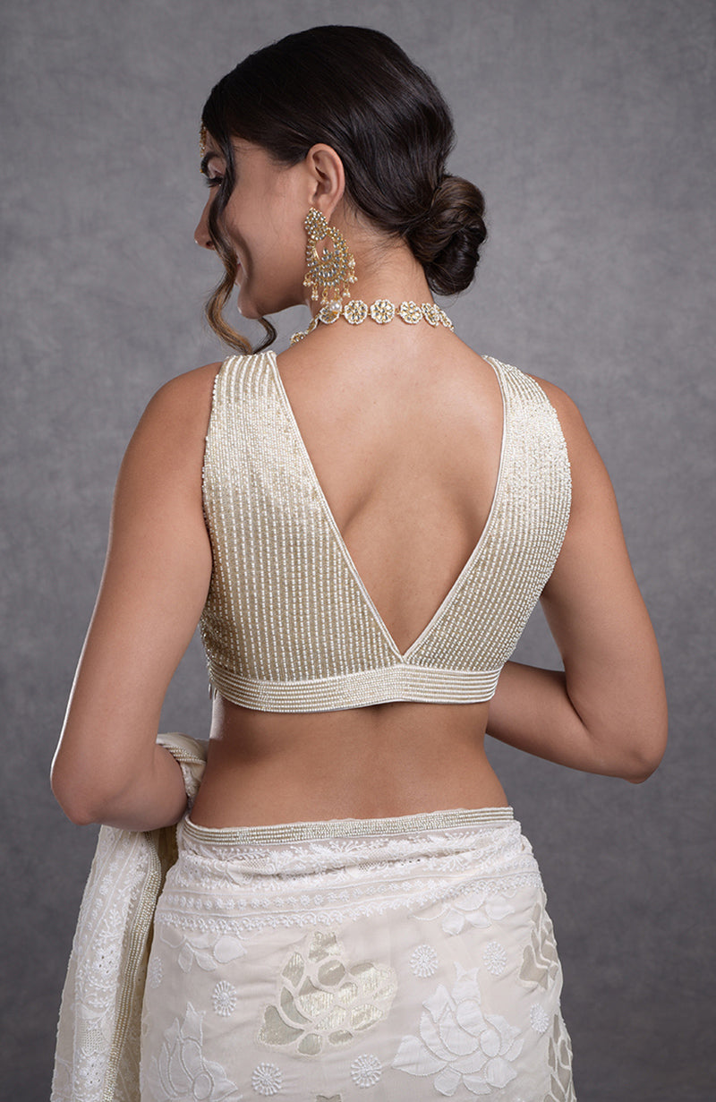 Ivory sleeveless blouse with hand-embroidered seed and rainbow cut beads on georgette fabric