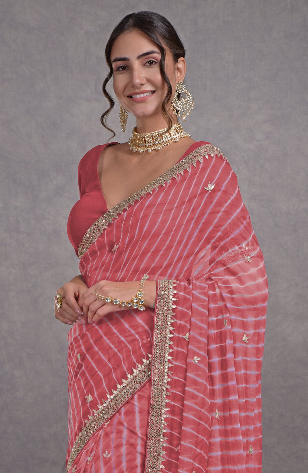 A woman in a garnet rose leheriya saree with rosegold marori-gota patti embroidery.