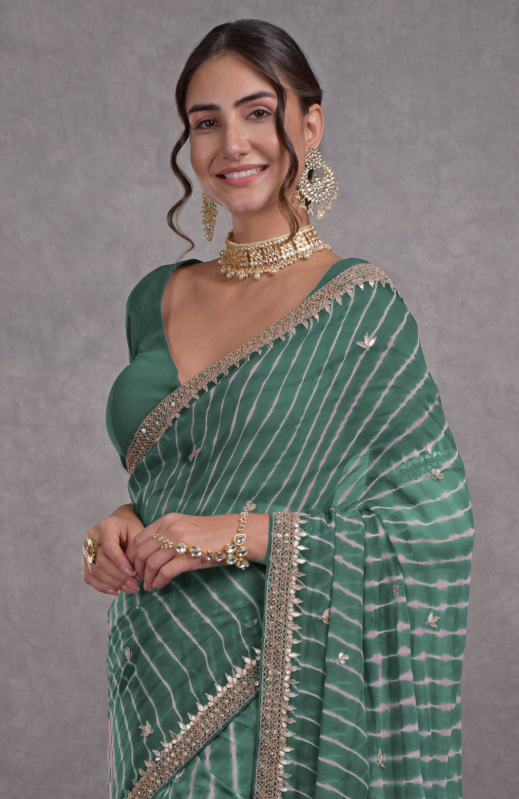 Woman in a jade leheriya saree with rosegold marori-gota patti embroidery.