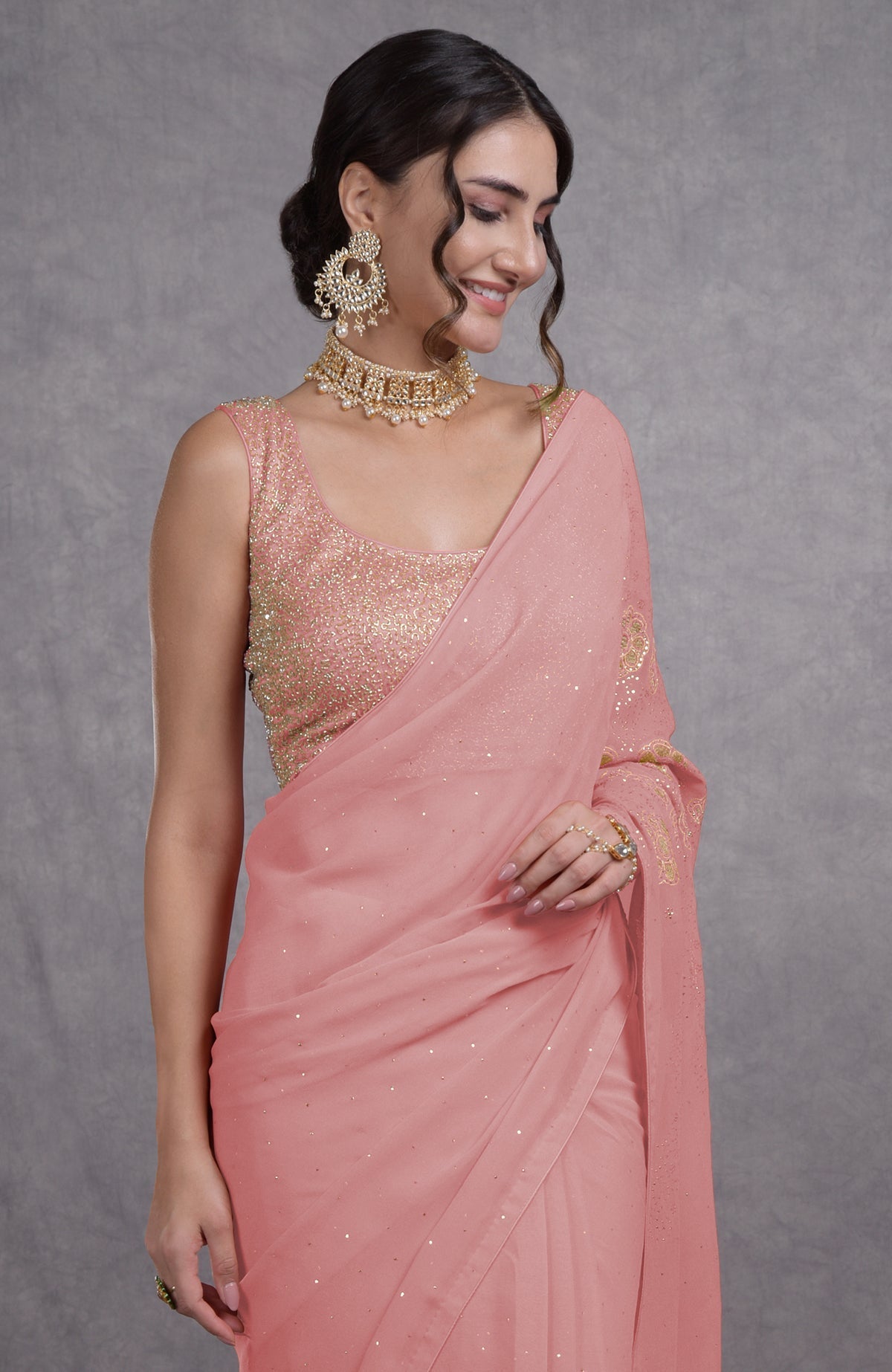 A woman models a pressed rose tissue cutwork hand-embroidered mukaish saree.