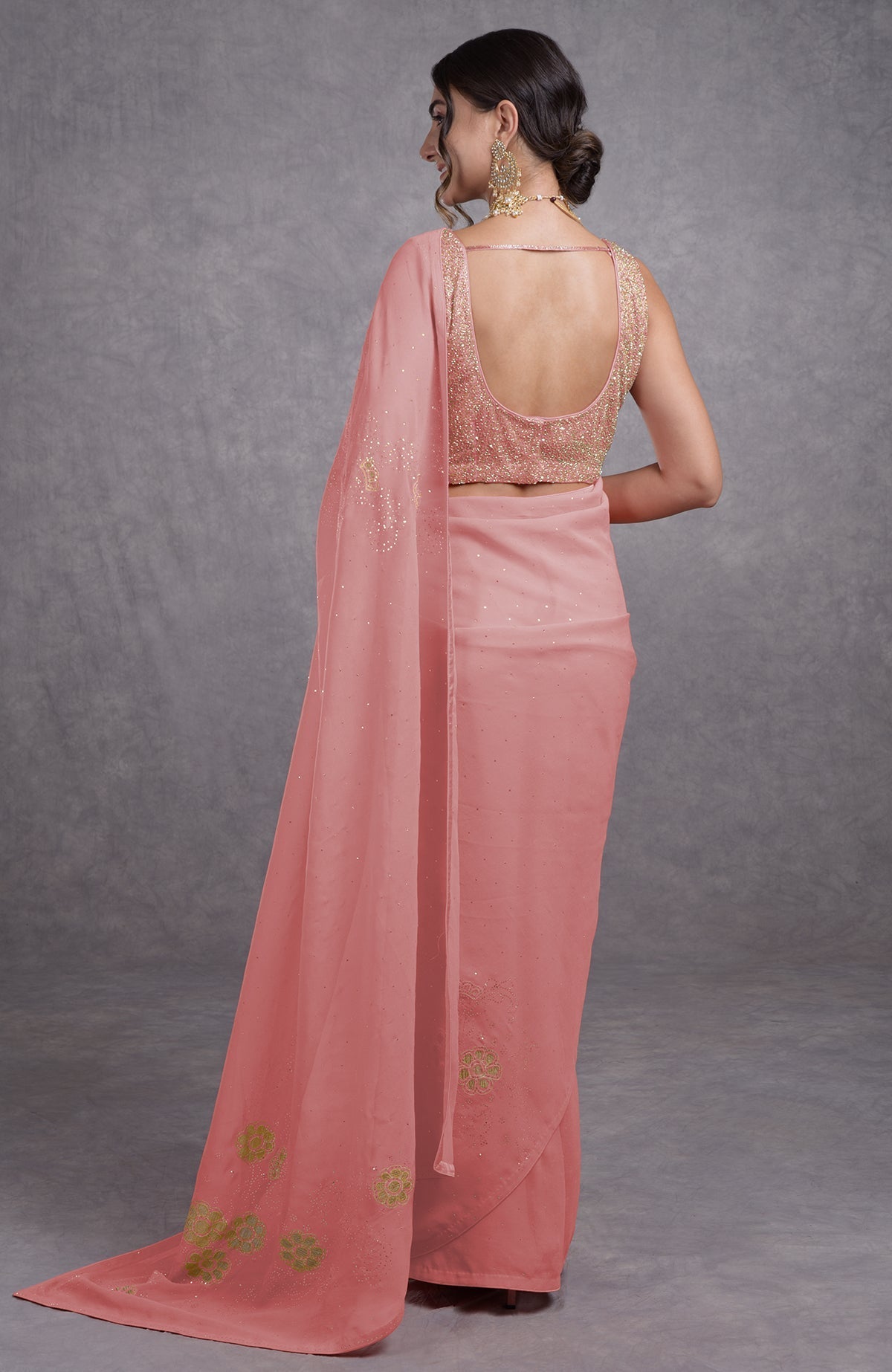 A woman from behind wears a pressed rose tissue cutwork hand-embroidered mukaish saree.