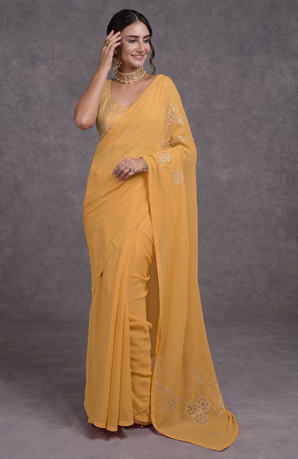A woman in a buff yellow tissue cutwork hand embroidered mukaish saree.