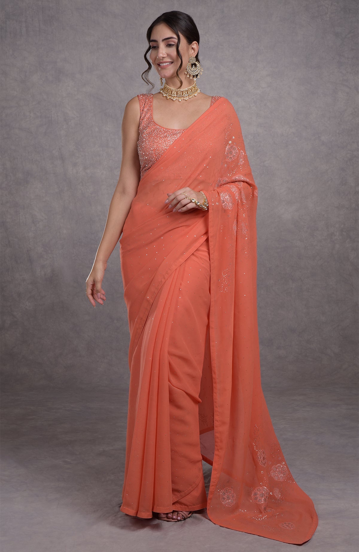 A woman models a pressed rose tissue cutwork hand-embroidered mukaish saree.