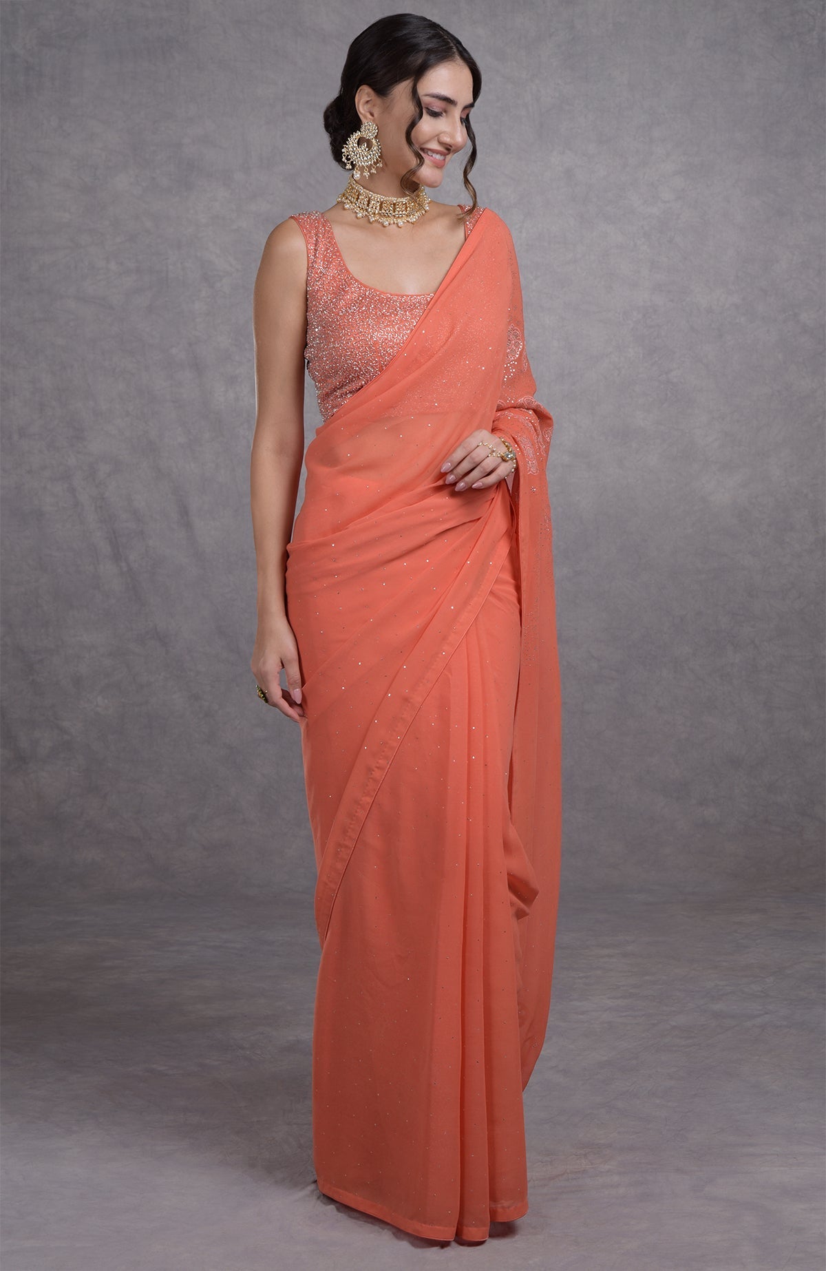 Peach camellia saree with hand-embroidered mukaish and tissue cutwork floral motifs.