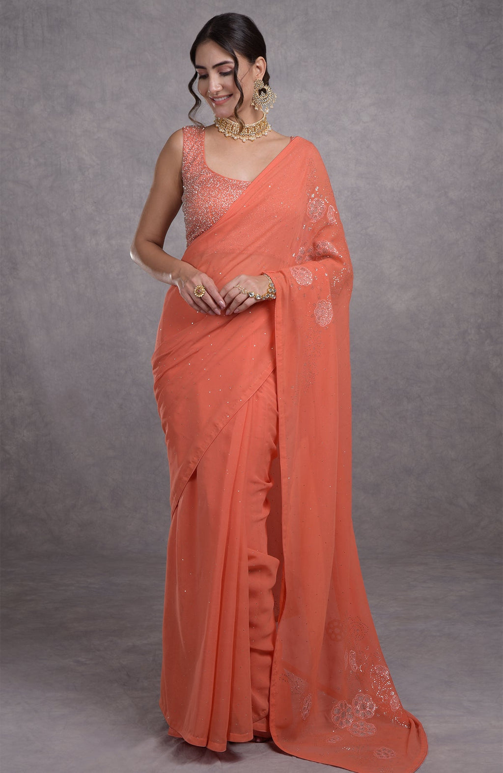 Peach camellia saree with hand-embroidered mukaish and tissue cutwork floral motifs.