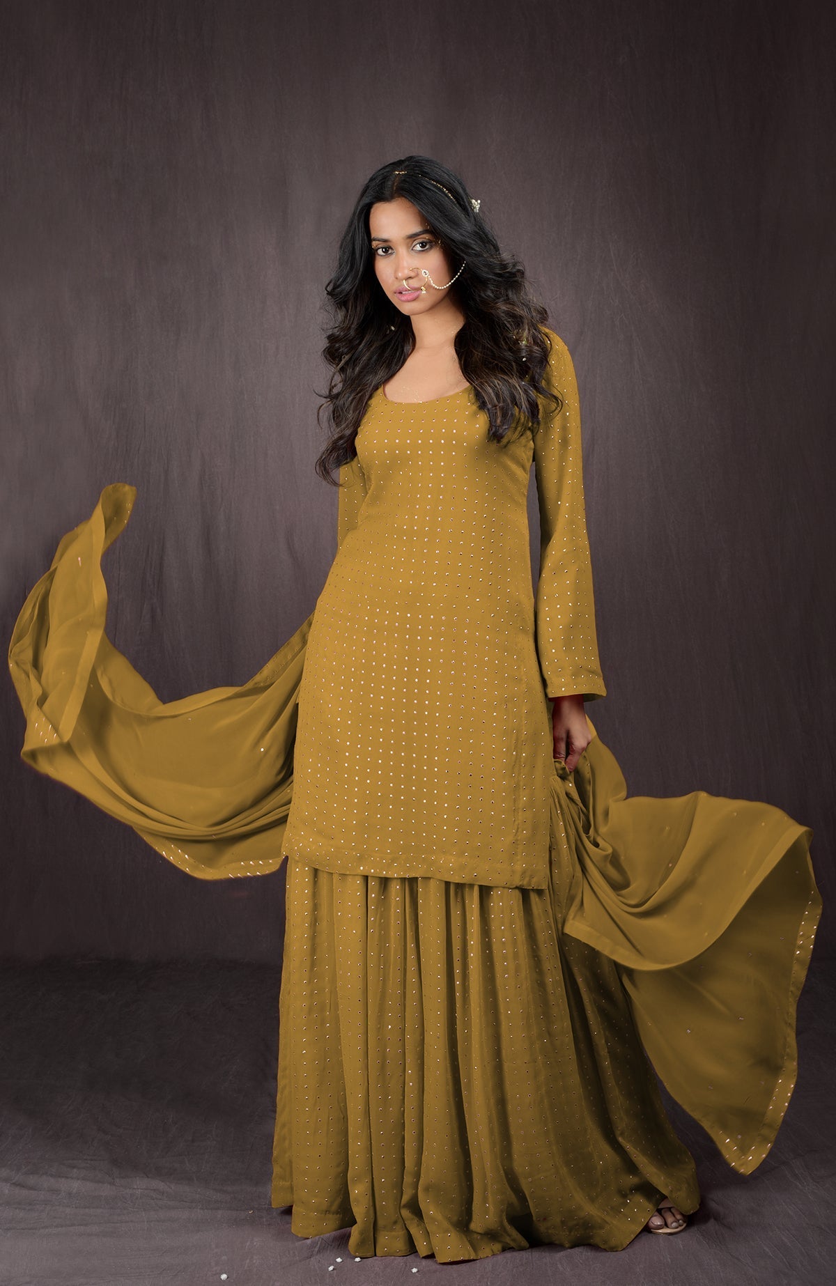 An olive-gold embellished sharara set with a matching dupatta.