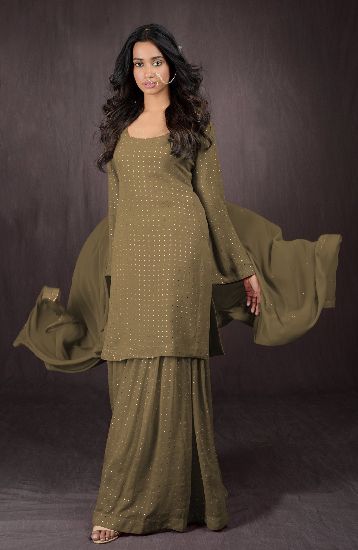 An olive gold embellished sharara set with a scoop neck and flowing dupatta.