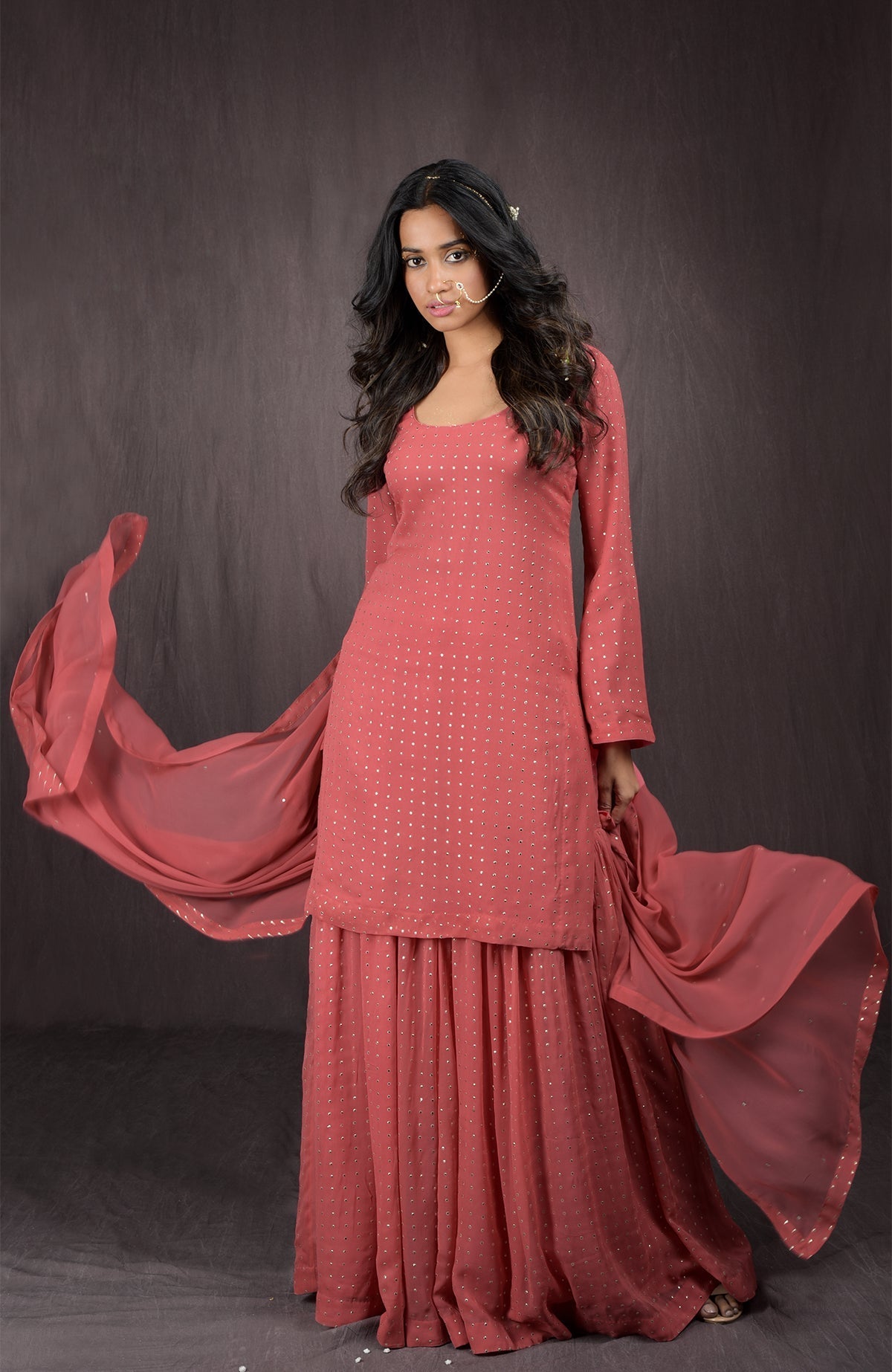 A woman models an Olive - Gold Embellished Sharara Set with a flowing dupatta.