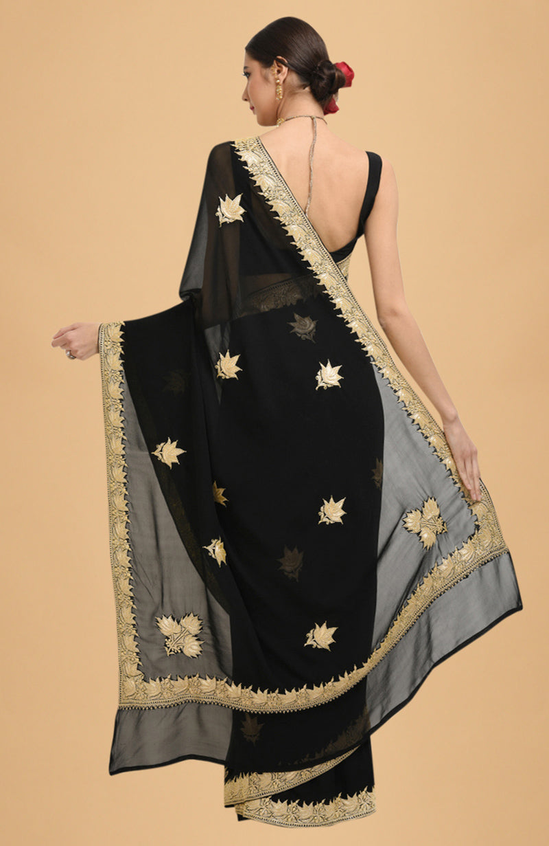 Black georgette saree with gold Kashmiri tilla lotus embroidery on pallav and borders.