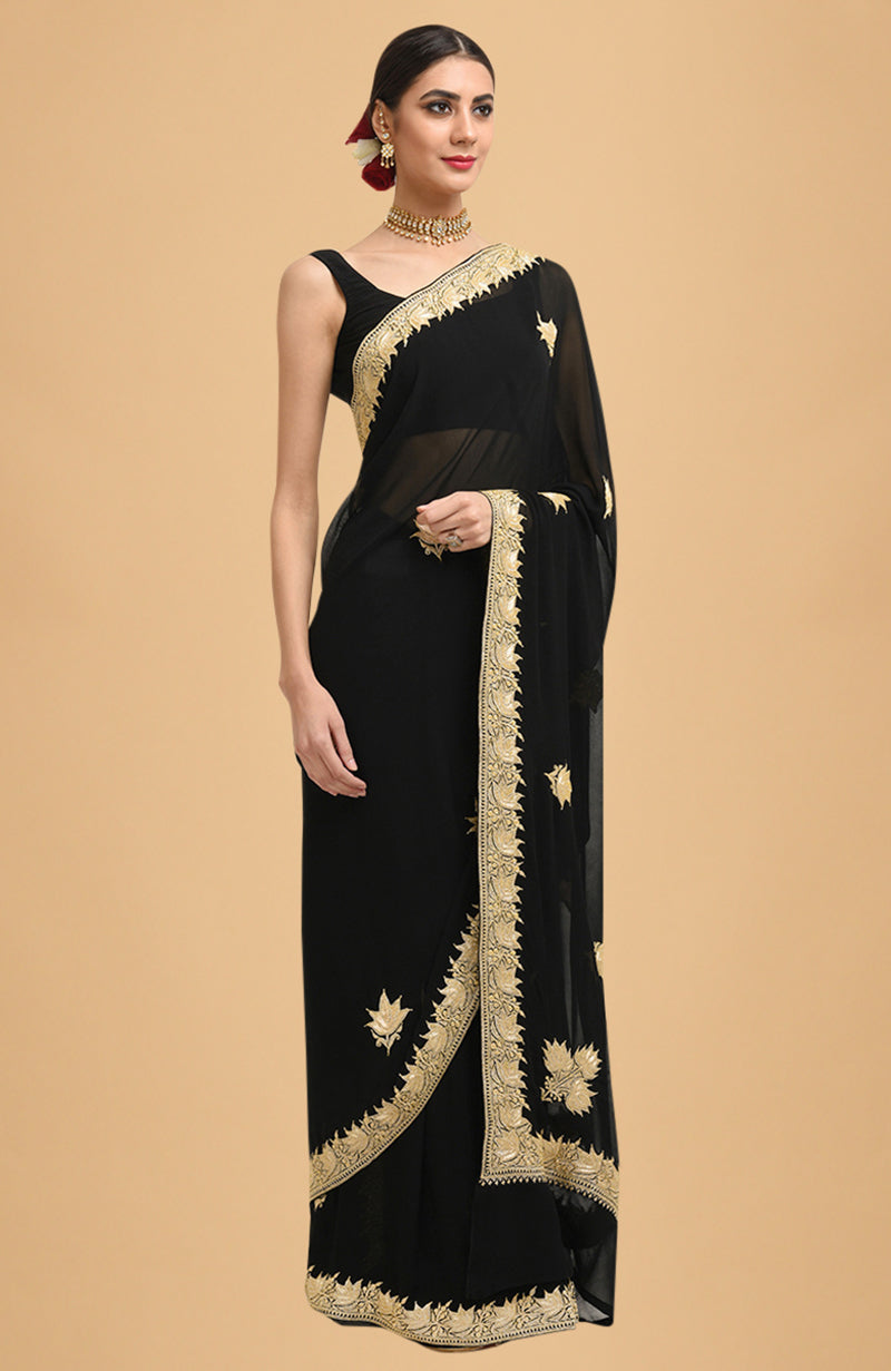 Black georgette saree with gold Kashmiri tilla lotus embroidery on pallav and borders.