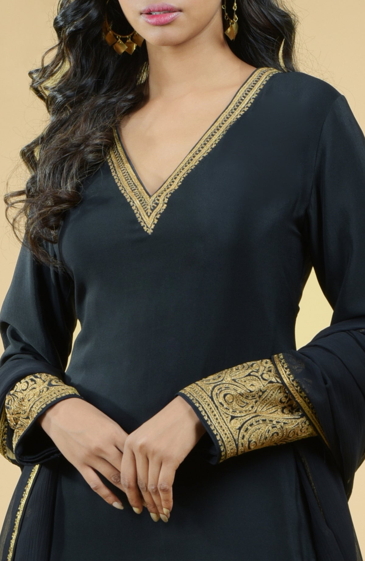 Black sharara set with gold Kashmiri Tilla Aari floral and paisley embroidery and chiffon dupatta.