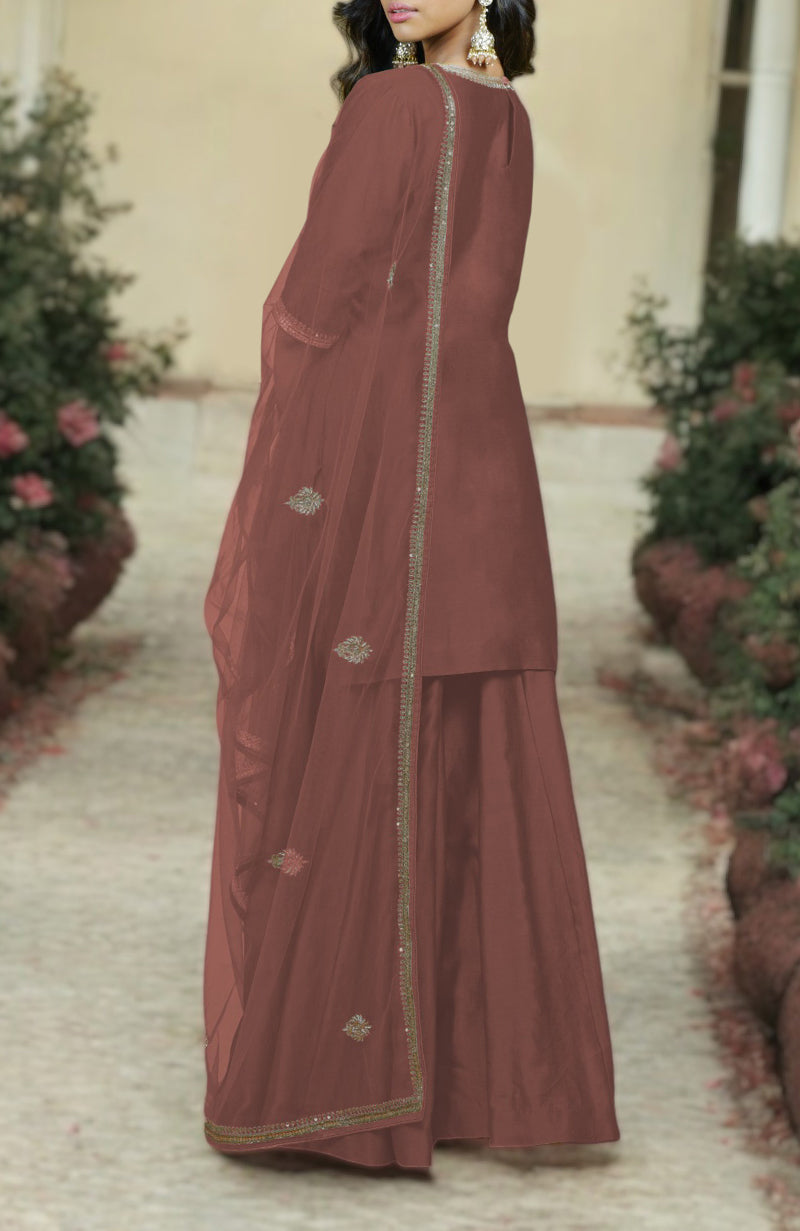A woman models a chutney-colored kurta set with gold zardozi embroidery.