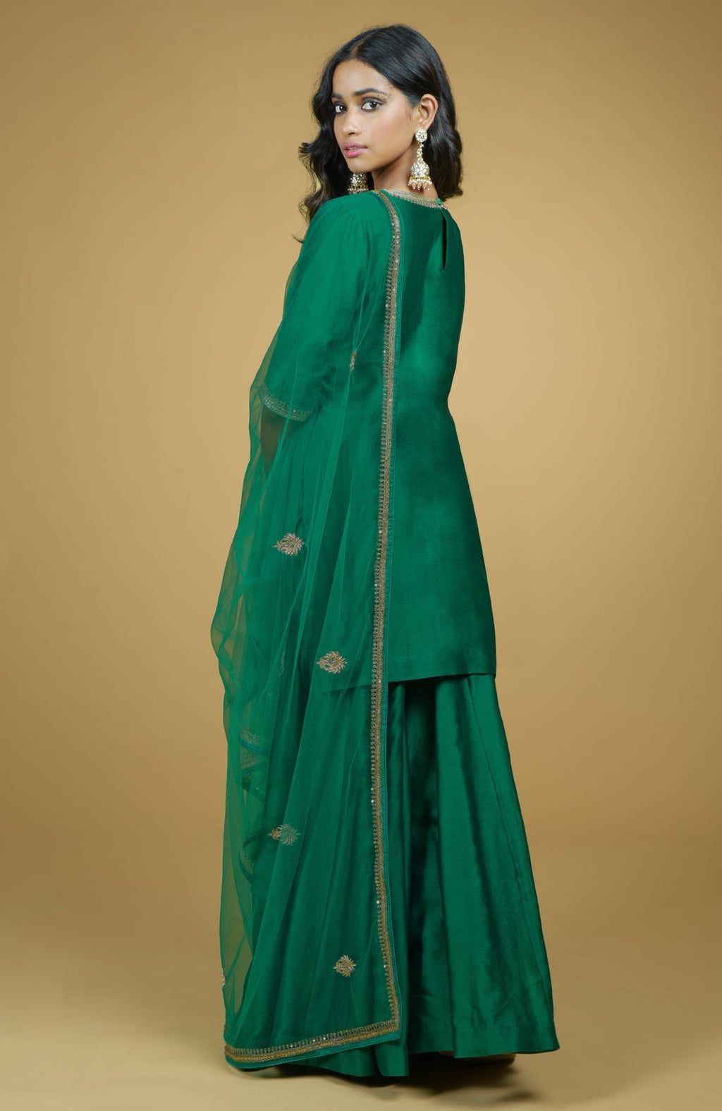 Emerald green Gharara set with gold hand-embroidered zardozi floral work and net dupatta.