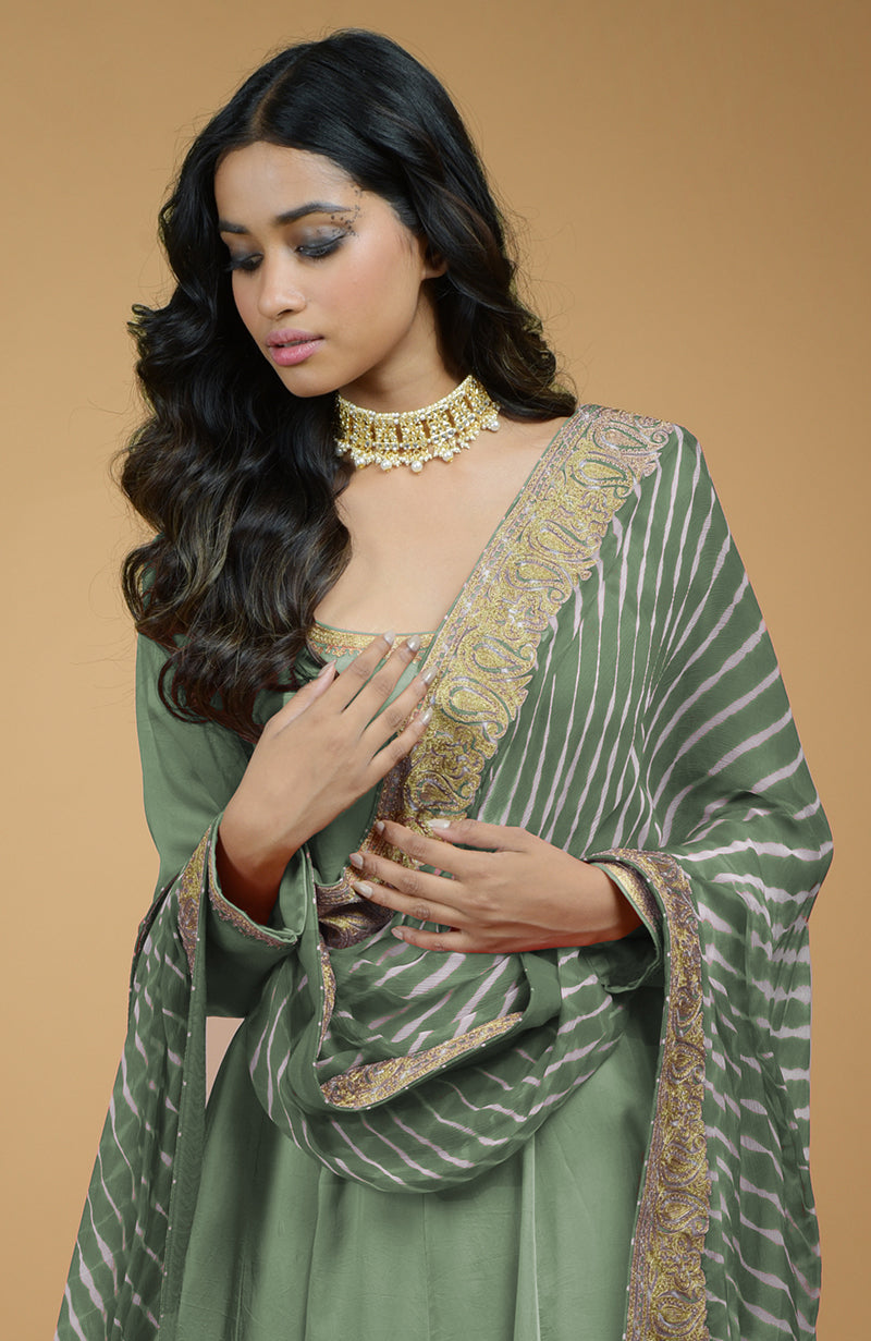 A woman models a jade green Anarkali set with a striped, embroidered dupatta.