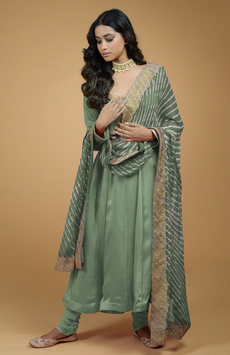 A woman models a greyish blue Anarkali set with a Leheriya-Tilla embroidered dupatta.