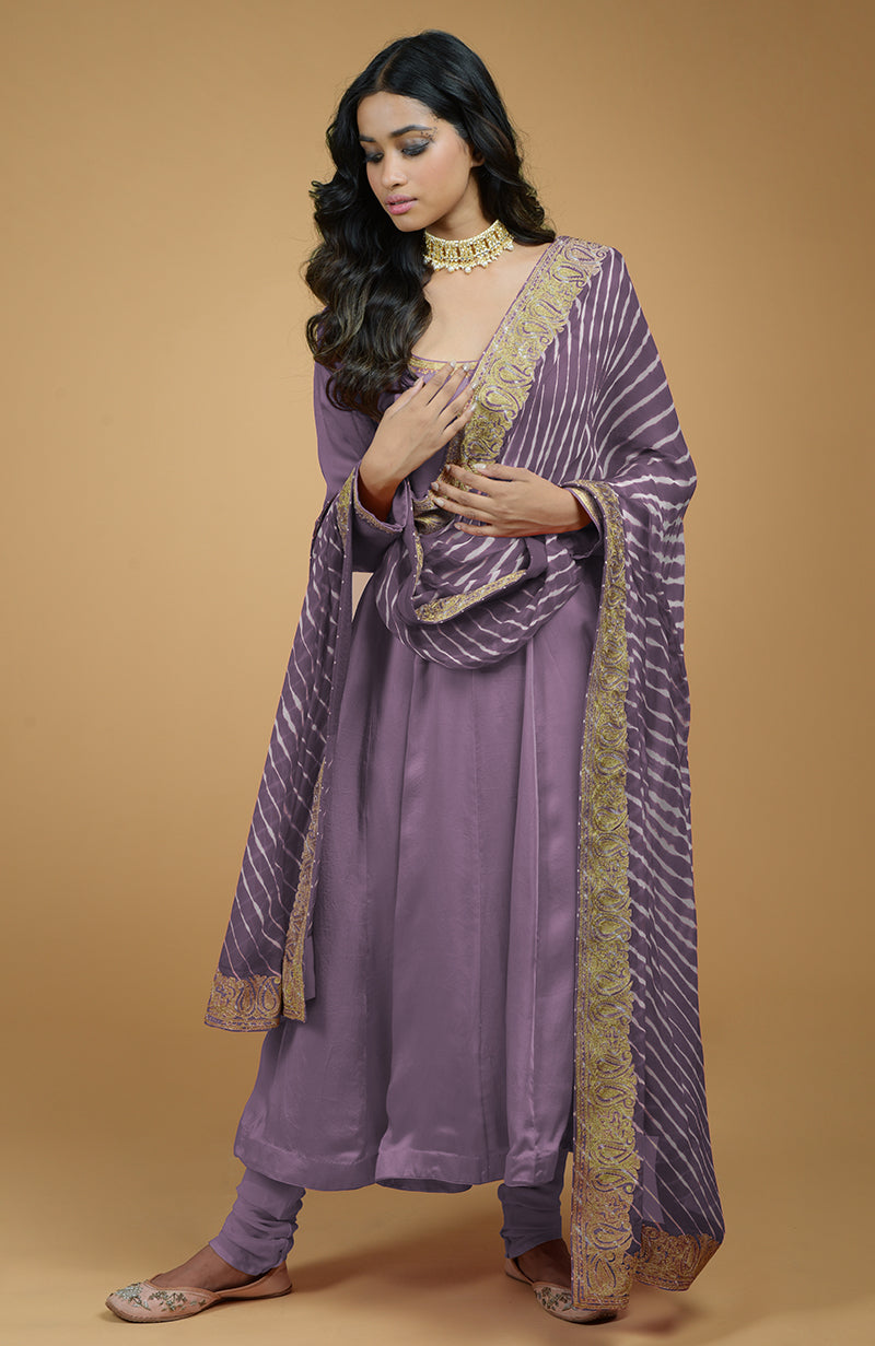 A woman models a mauve Anarkali set with a leheriya-tilla embroidered dupatta.