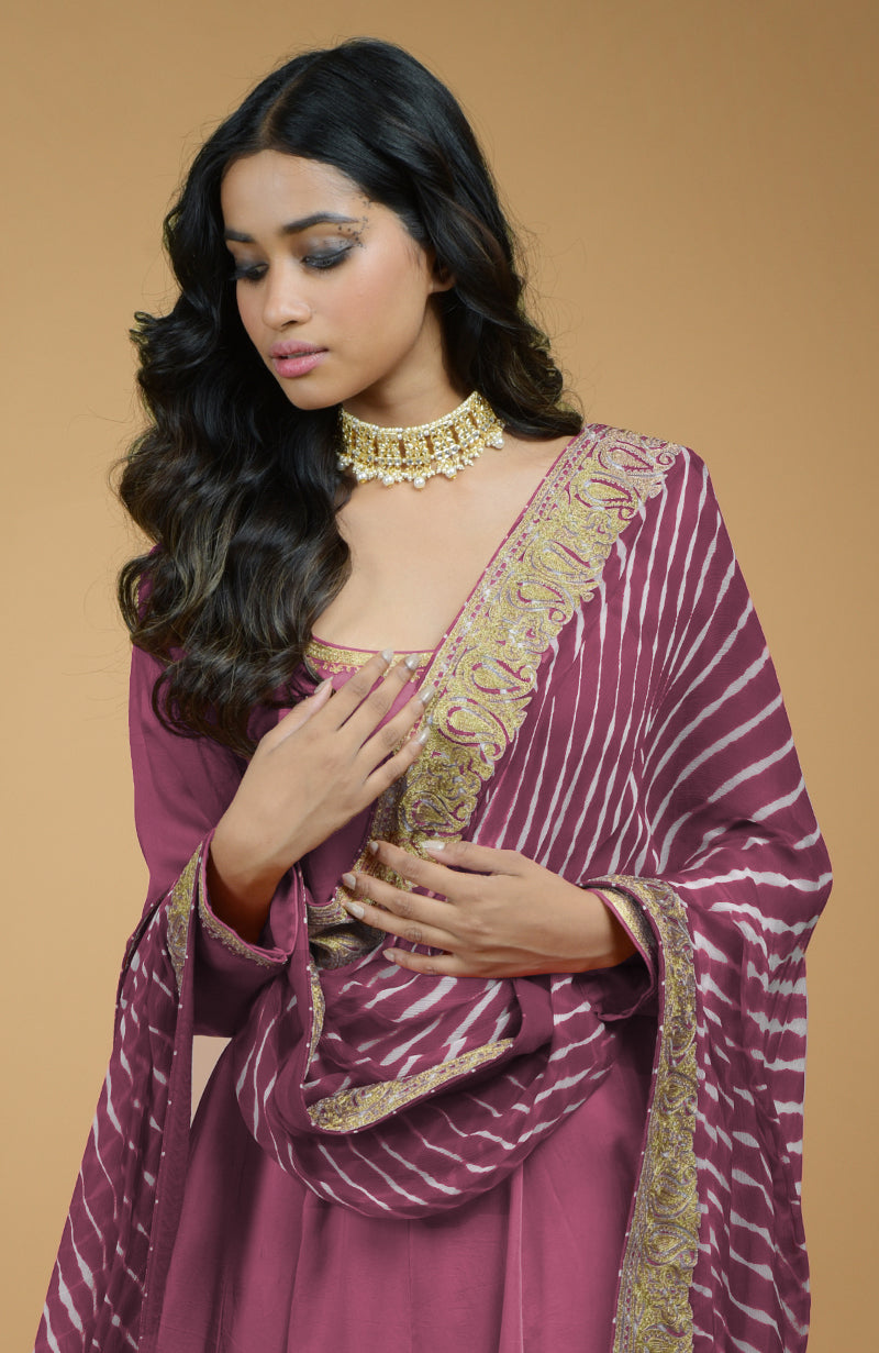 A woman models a mauve Anarkali set with a leheriya-tilla embroidered dupatta.