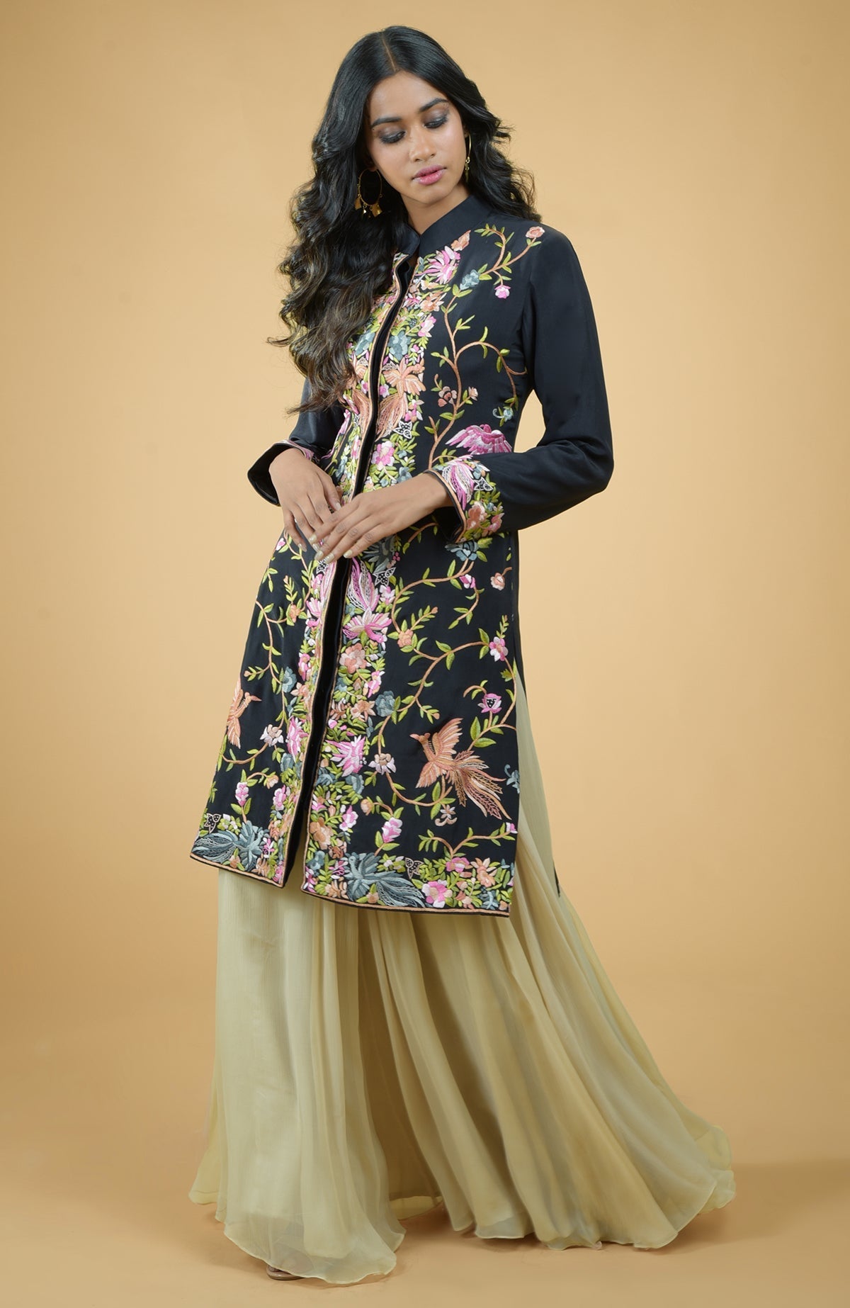 Black Parsi Gara embroidered crepe jacket with multicolor floral and bird designs, paired with gold skirt