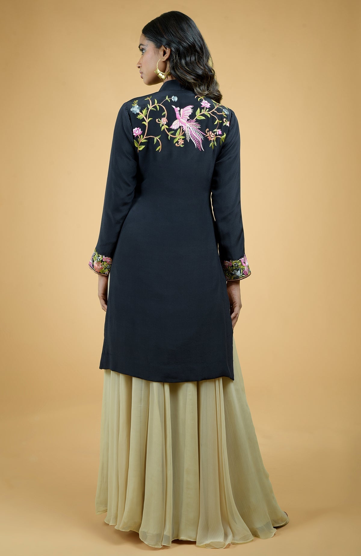 Black Parsi Gara embroidered crepe jacket with multicolor floral and bird designs paired with light gold skirt