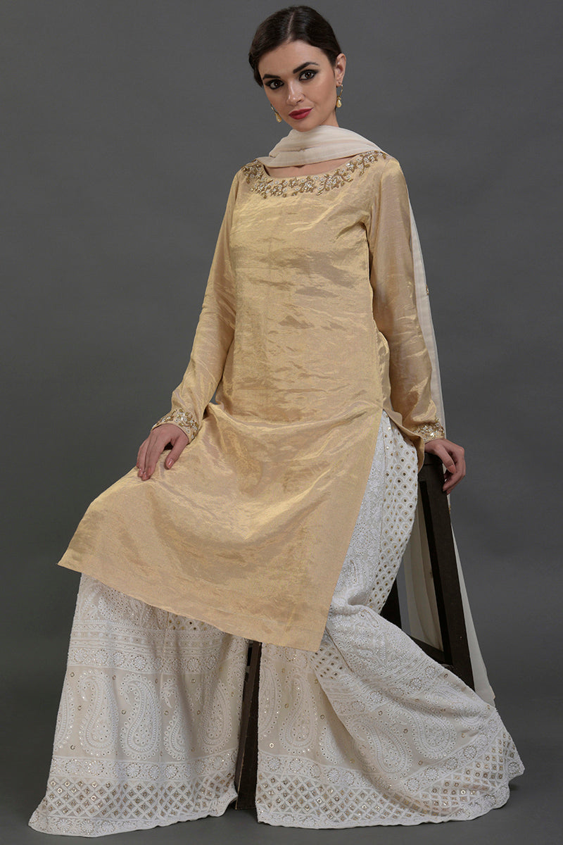 Ivory-gold silk tissue kurta with chikankari sharara and georgette dupatta with gold embroidery.