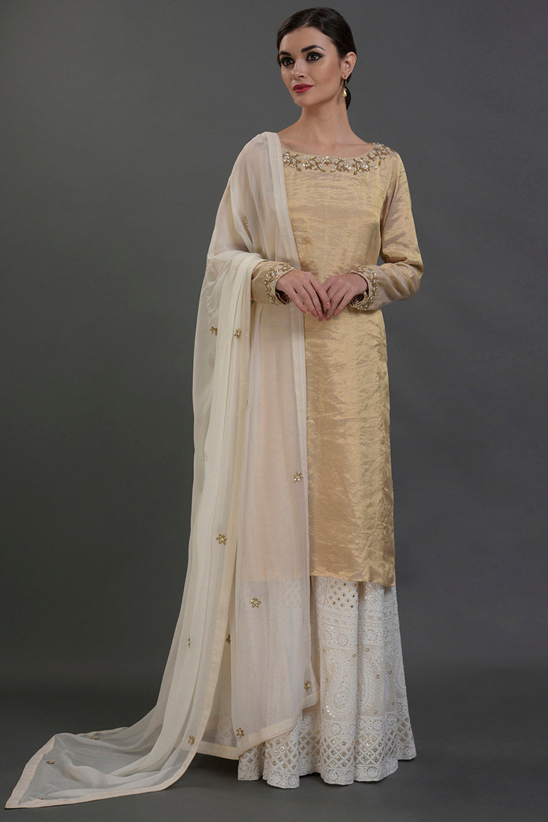 Ivory-gold silk tissue kurta with chikankari and zardozi embroidery paired with georgette sharara and dupatta.