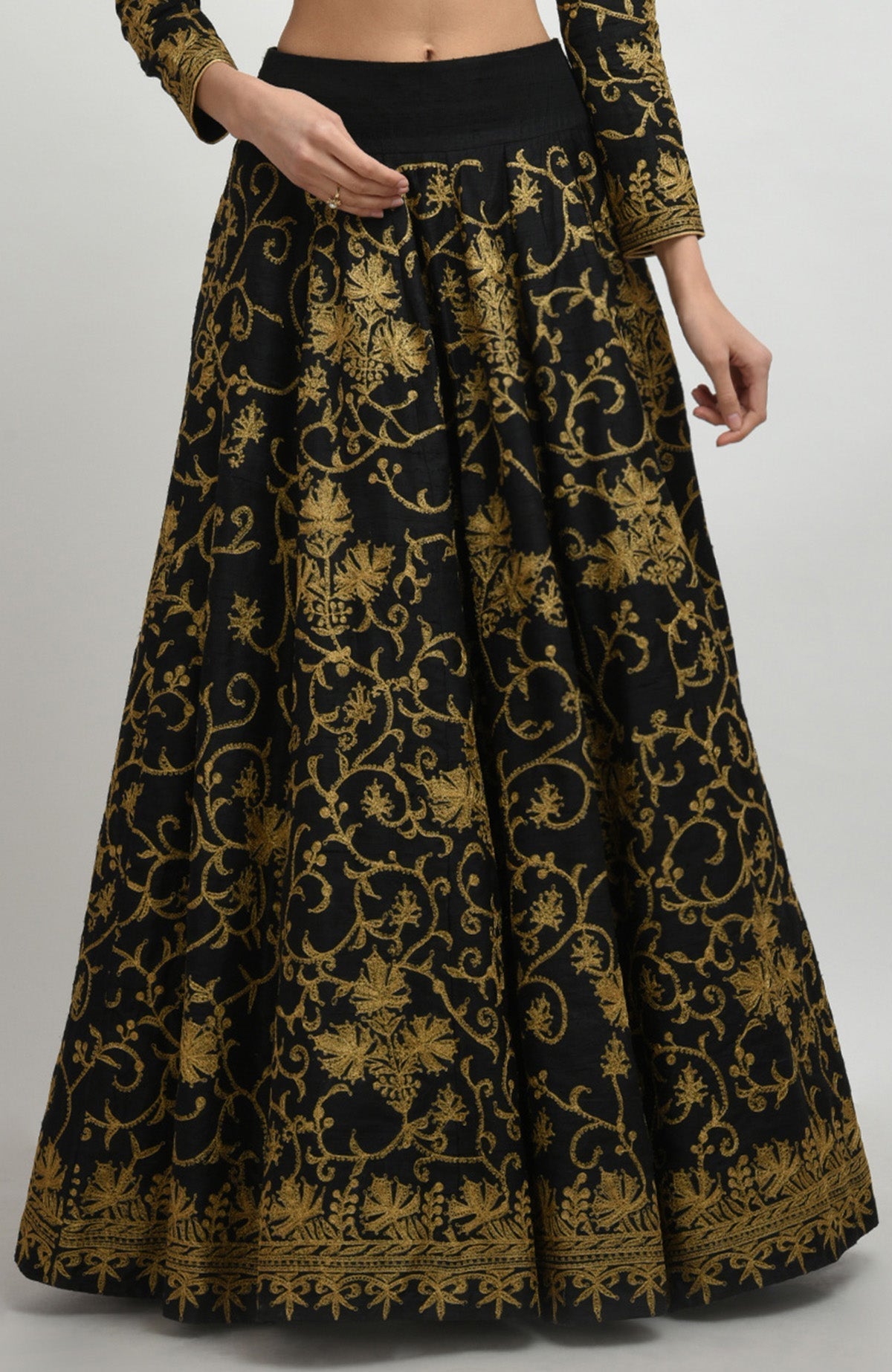 Black raw silk lehenga set with gold Kashmiri tilla aari embroidery and net dupatta with sequins.