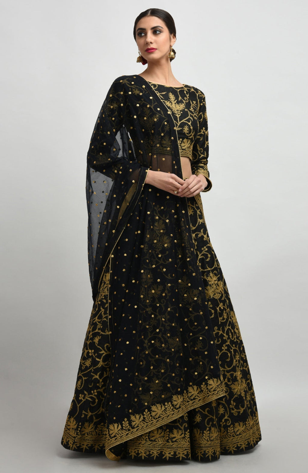 Black raw silk lehenga set with gold Kashmiri tilla aari embroidery and net dupatta with gold borders.