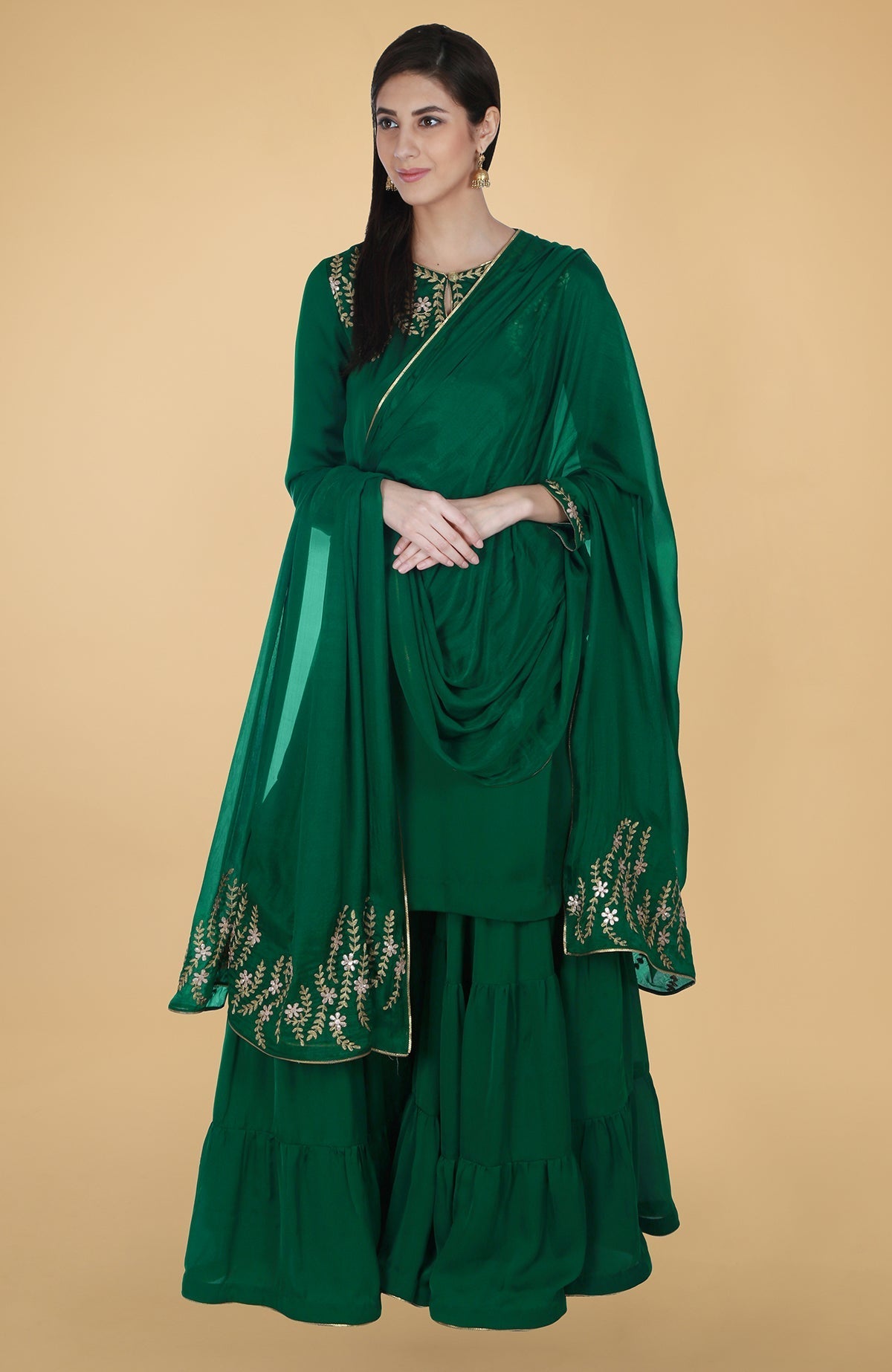 Emerald green satin chiffon gharara suit with gold gota patti floral embroidery and piping details.