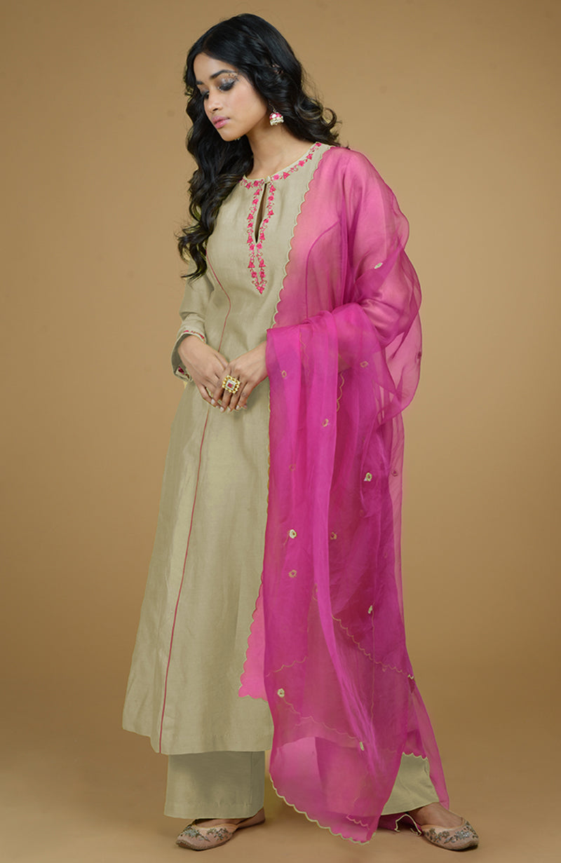Beige kurta set with magenta embroidery and a sheer magenta organza dupatta.