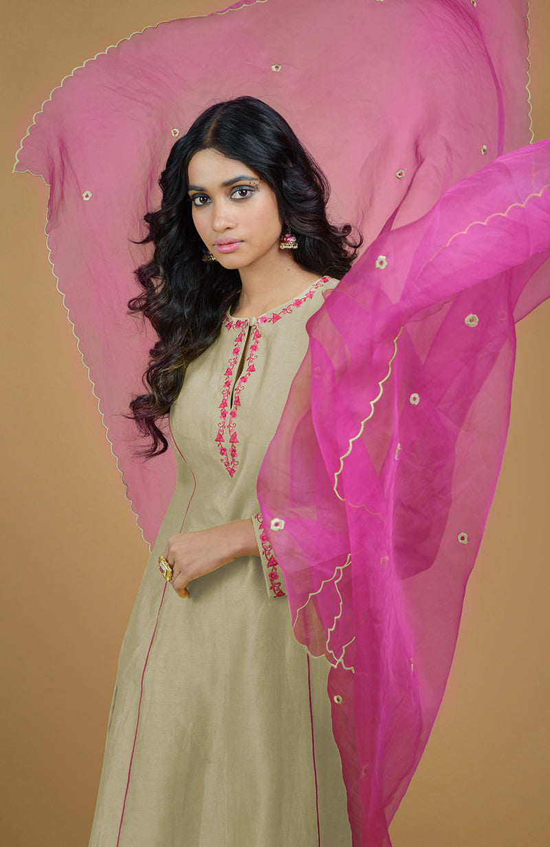 A woman models a beige kurta with pink embroidery and a flowing magenta organza dupatta.