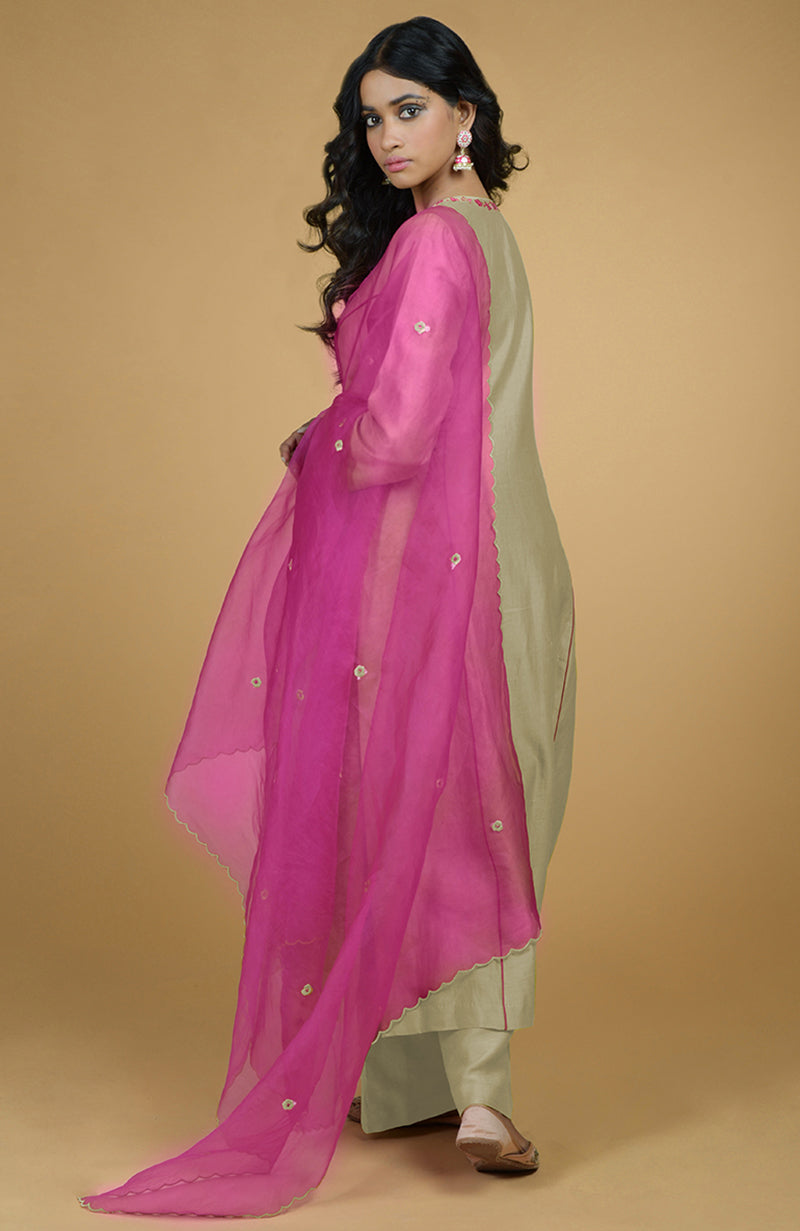 A woman models a beige kurta set with a magenta organza dupatta.