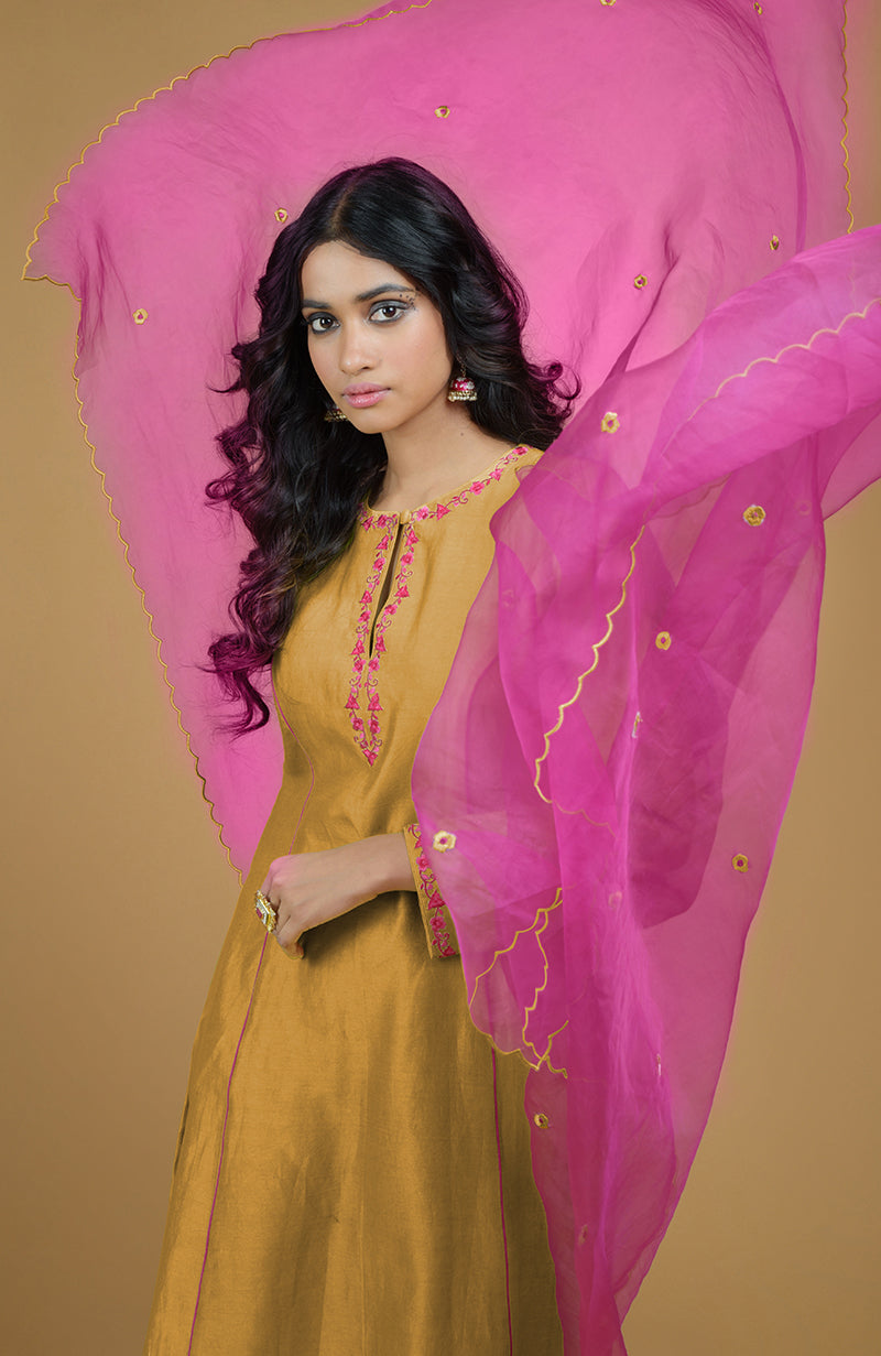 Mustard kurta set with magenta embroidery and a matching organza dupatta.