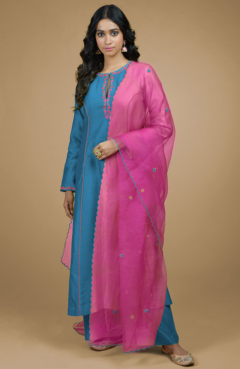 A woman models a beige and magenta organza kurta set with a teal kurta and pink dupatta.