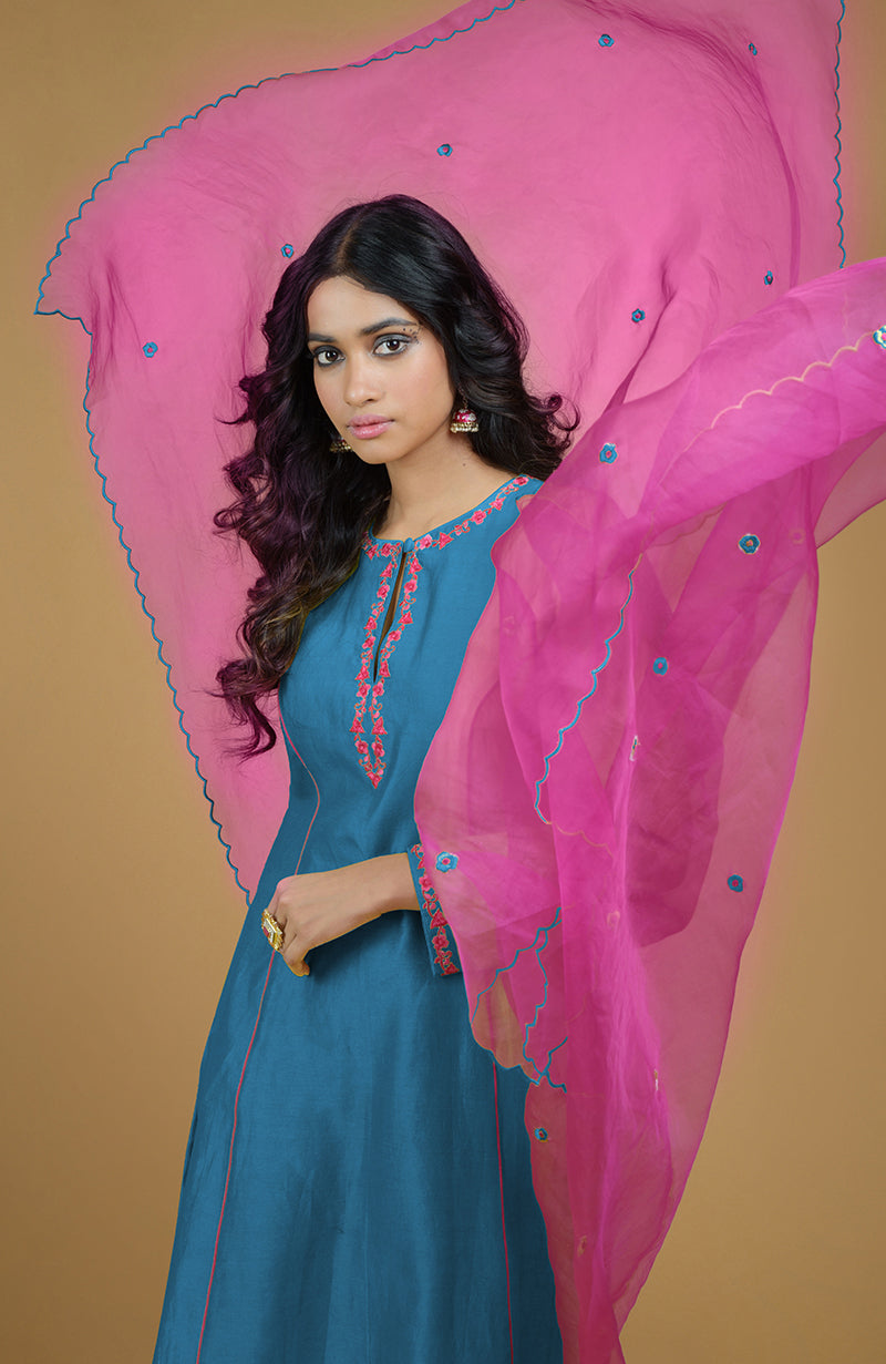 A woman models a blue kurta set with a magenta organza dupatta.