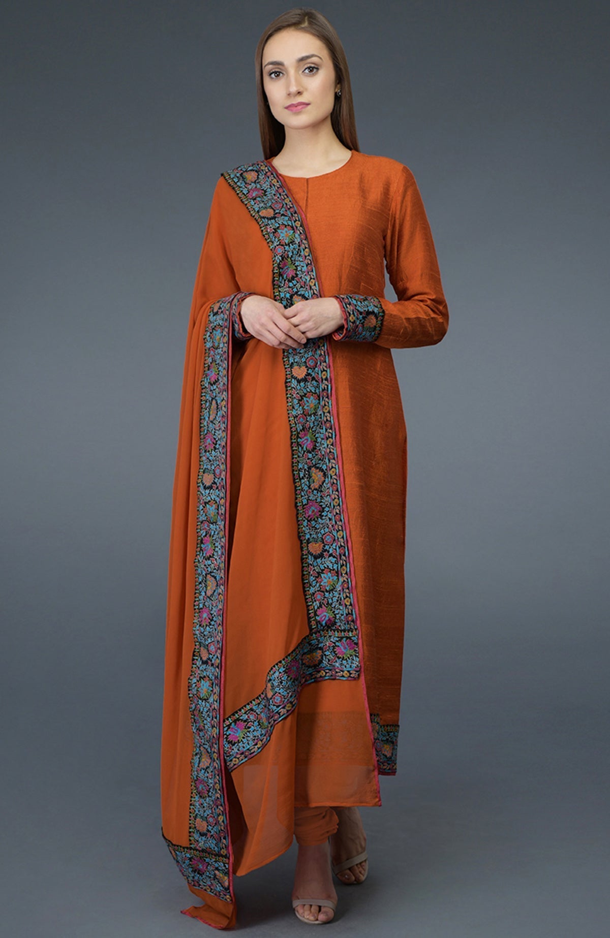 Burnt orange raw silk suit with jewel neckline and multicolor Kashmiri hand embroidery on shirt and dupatta borders